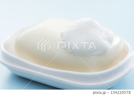 水色背景に映える泡の乗った固形石けんの清潔感あふれる日用品イメージ 134220578