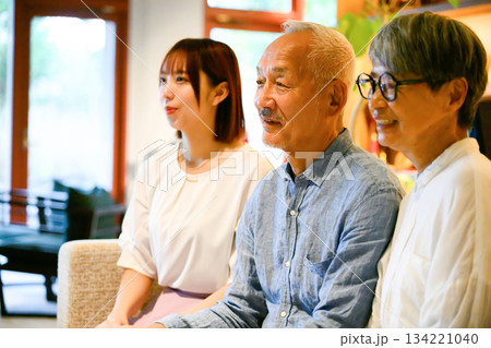 シニア夫婦と若い女性の談笑 シニア夫婦と若い女性の談笑 134221040
