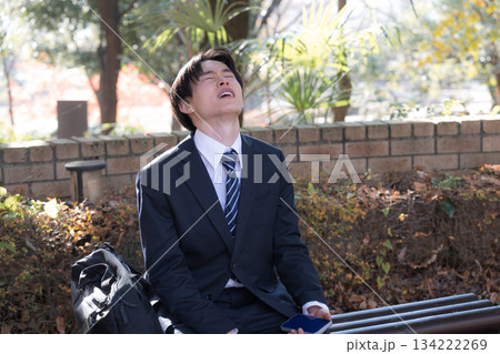 外回りの営業でベンチに座って悩む男性ビジネスマン 外回りの営業でベンチに座って悩む男性ビジネスマン 134222269