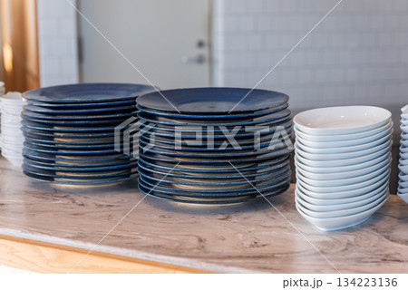 白と青い皿が整然と並ぶ飲食店のキッチンカウンター 134223136