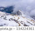 Davos, Switzerland - October 7th 2025: First autumnal snow on the alpine peak Schiahorn surrounded b clouds 134224361