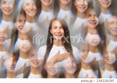 Creative optical illusion portrait of woman with multiple reflections holding hand on chest smiling Creative optical illusion portrait of woman with multiple reflections holding hand on chest smiling 134226295