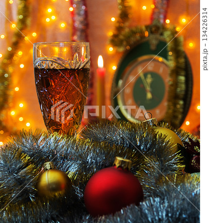 Glass of wine on the background of the clock with the lack of focus Glass of wine on the background of the clock with the lack of focus 134226314
