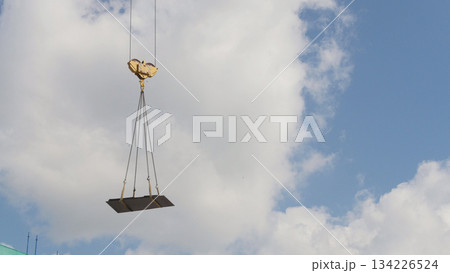 A crane lifting heavy equipments on a construction site - in front of blue sky A crane lifting heavy equipments on a construction site - in front of blue sky 134226524