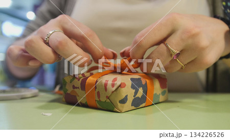 Wrapping gift - close up view woman's hands Wrapping gift - close up view woman's hands 134226526