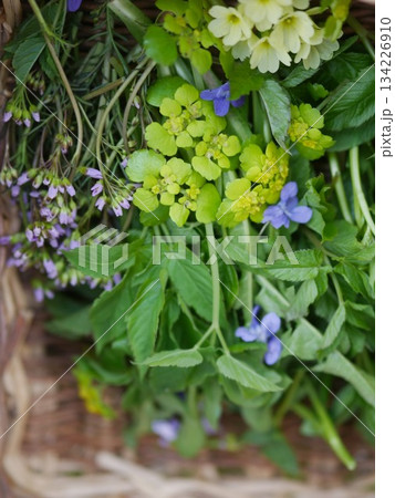Basket of herbs and flowers with a blue flower in the middle 134226910