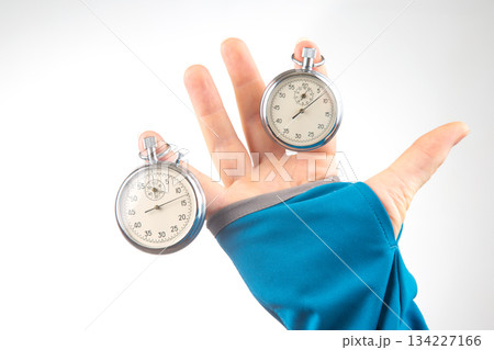 Two mechanical stopwatches hang on the fingers of a male hand Two mechanical stopwatches hang on the fingers of a male hand 134227166