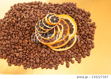 Rustic arrangement of coffee beans and dried orange slices on a golden background Rustic arrangement of coffee beans and dried orange slices on a golden background 134227167