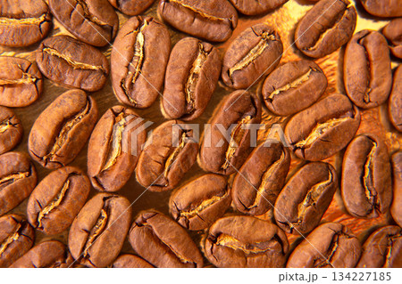 Gourmet close-up of roasted coffee beans with golden reflections 134227185