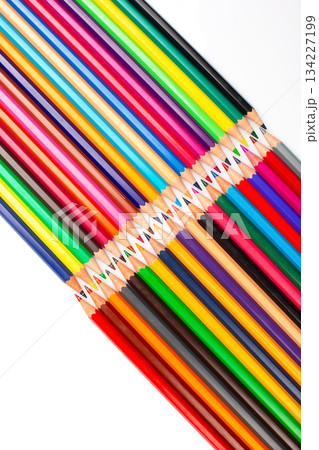 A spectrum of sharpened colored pencils layered in a grid on a white background. 134227199