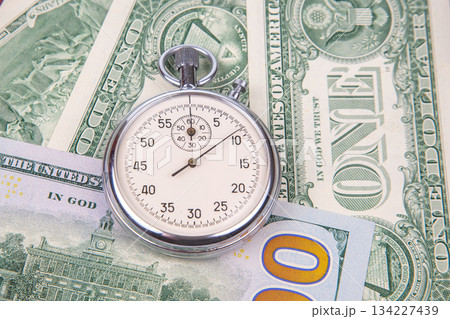 mechanical stopwatch on the background of dollars mechanical stopwatch on the background of dollars 134227439