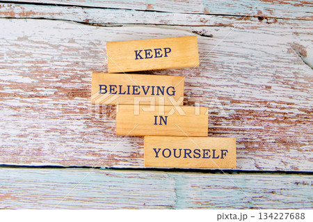 Wooden blocks stack together to form an uplifting message encouraging everyone to keep believing in themselves. The natural texture of the wood adds warmth to the messages significance 134227688