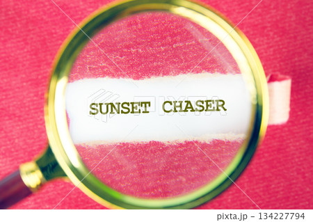 This scene showcases the words sunset chaser under a magnifying lens, framed by a vivid backdrop, inviting the viewer to ponder on the magic of sunlit evenings and adventure This scene showcases the words sunset chaser under a magnifying lens, framed by a vivid backdrop, inviting the viewer to ponder on the magic of sunlit evenings and adventure 134227794