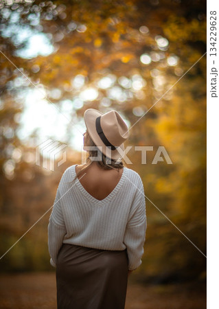 Woman Autumn Forest Hat: Back view, Fall fashion, outdoor portrait, nature scenery. Woman Autumn Forest Hat: Back view, Fall fashion, outdoor portrait, nature scenery. 134229628