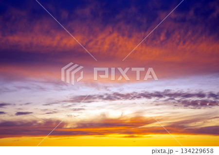 Vibrant sunset over the horizon with a colorful sky of orange, pink, and blue hues Vibrant sunset over the horizon with a colorful sky of orange, pink, and blue hues 134229658