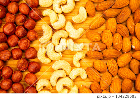 assorted nuts on a kitchen wooden board. vitamin vegetarian food assorted nuts on a kitchen wooden board. vitamin vegetarian food 134229685