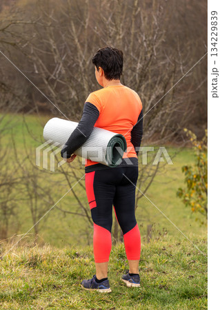 Woman carrying a yoga mat 134229839