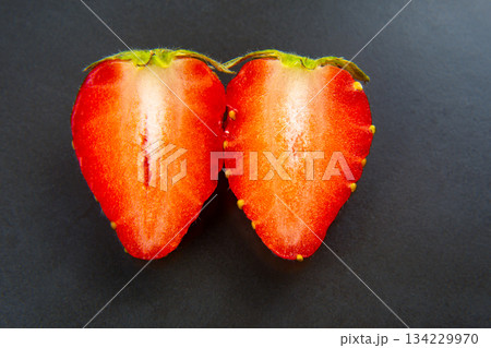 half of a strawberry on a green background 134229970