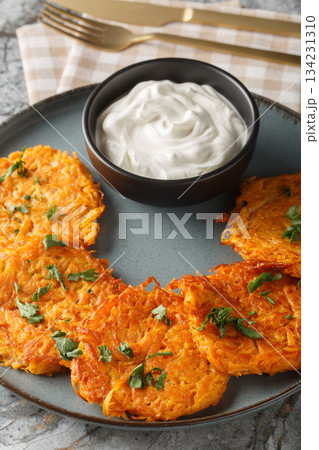 Sweet Potato Hash Browns served with sour cream closeup on the plate. Vertical Sweet Potato Hash Browns served with sour cream closeup on the plate. Vertical 134231310