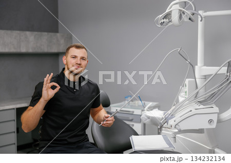 Dentist showing OK sign in modern dental clinic 134232134