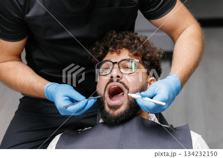 Dentist checking patient teeth during dental examination Dentist checking patient teeth during dental examination 134232150