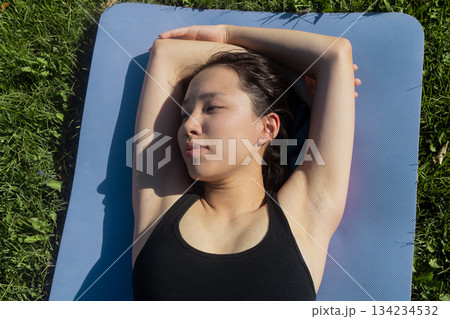 Fit woman stretching her neck and shoulder muscles before an outdoor workout Fit woman stretching her neck and shoulder muscles before an outdoor workout 134234532