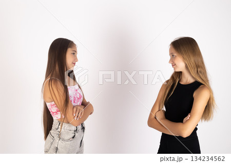 Two teenage girls standing and looking away from each other in studio 134234562