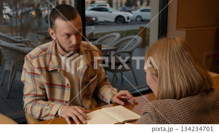 Young man talking and explaining a concept to his partner in a cafe Young man talking and explaining a concept to his partner in a cafe 134234701