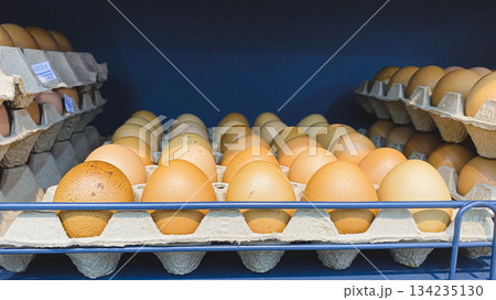 Fresh Brown Chicken Eggs in Cardboard Trays on Supermarket Shelf for Food, Nutrition, and Grocery Shopping Concept 134235130