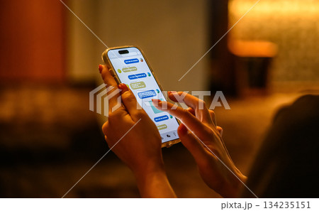 暗闇でスマホのメッセージを打つ手元 134235151