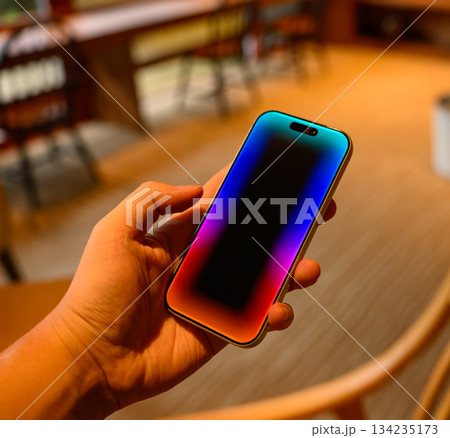 手持ちのスマートフォンとカラフルな画面 手持ちのスマートフォンとカラフルな画面 134235173