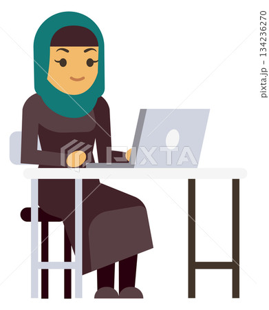 A woman wearing a green scarf is sitting at a desk with a laptop 134236270