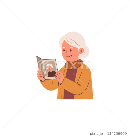 Nostalgic remembrance: elderly woman tenderly gazing at a cherished portrait photo from her past 134236909