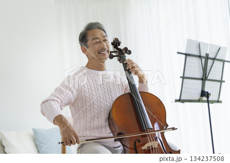 チェロを弾く笑顔のシニア男性 134237508