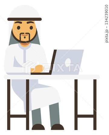 A man wearing a white robe sits at a desk with a laptop 134239010