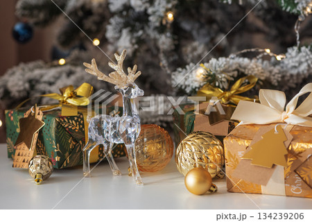 Crystal Reindeer with Gold Antlers and Christmas Gifts in Festive Interior Crystal Reindeer with Gold Antlers and Christmas Gifts in Festive Interior 134239206