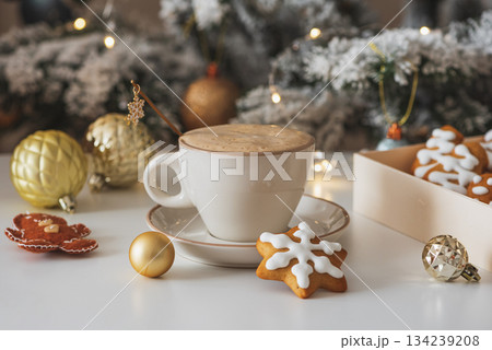 Cup of Hot Coffee with Christmas Gingerbread Cookies and Ornaments in Festive Setting Cup of Hot Coffee with Christmas Gingerbread Cookies and Ornaments in Festive Setting 134239208