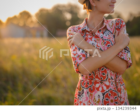 young woman embracing herself, self-love in action, mental health advocate, practicing self-care for finding inner peace, in European countryside 134239344