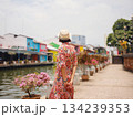 Young woman in ethnic dress and hat exploring the vibrant streets of Malacca, Malaysia. A blend of cultural heritage, colorful architecture, and tropical charm. Perfect travel and lifestyle moments. 134239353