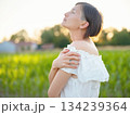 Beautiful woman in white dress standing in summer field during golden sunset in Croatia, warm sunlight, romantic evening mood, natural countryside atmosphere, soft wind and peaceful scene 134239364