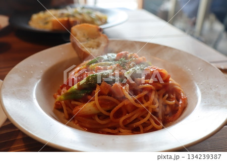 濃厚なクリームパスタにガーリックトーストを添えた、温かみある食卓風景。飲食店のメニュー撮影、SNS投 134239387