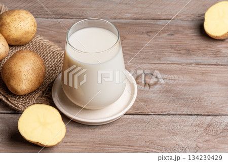 Vegan potato milk on wooden background Vegan potato milk on wooden background 134239429