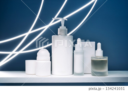 Skincare bottles and pipettes on white shelf with neon lights Skincare bottles and pipettes on white shelf with neon lights 134241031