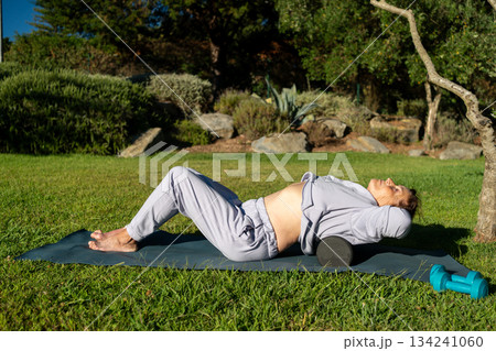 Senior woman massaging back muscles with foam 134241060