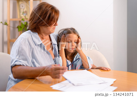 Disinterested granddaughter ignoring homework with 134241071