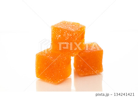 Three orange cubes of marmalade candy on a white background Three orange cubes of marmalade candy on a white background 134241421