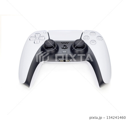 A white and black PS5 controller. The gamepad is sitting on a white surface A white and black PS5 controller. The gamepad is sitting on a white surface 134241460