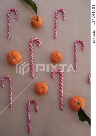 Vertical View of Heart-Shaped Candy Canes with Tangerines on Beige 134241581