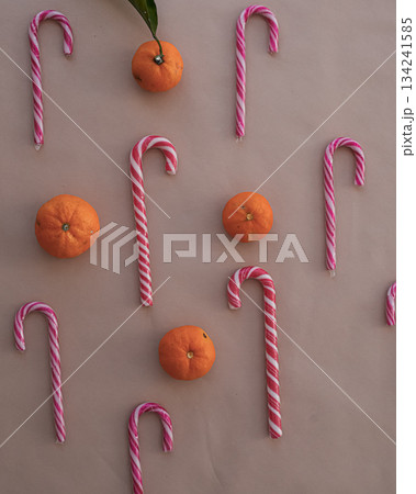 Festive Heart-Shaped Candy Canes with Tangerines on Beige Background 134241585