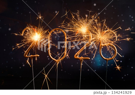 Sparkling New Year 2026. Glowing sparklers forming the number 2026 against a starry night sky 134241929